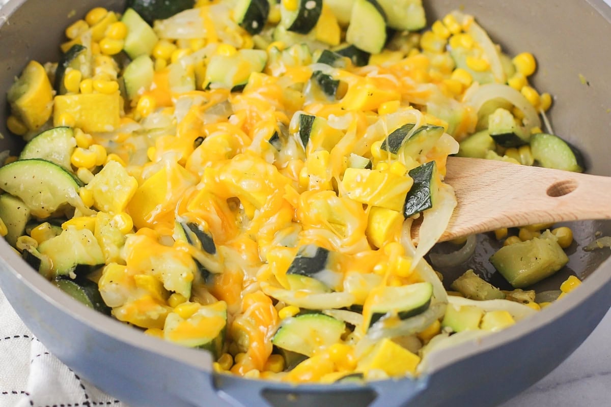 A skillet of calabacitas topped with melted cheese.