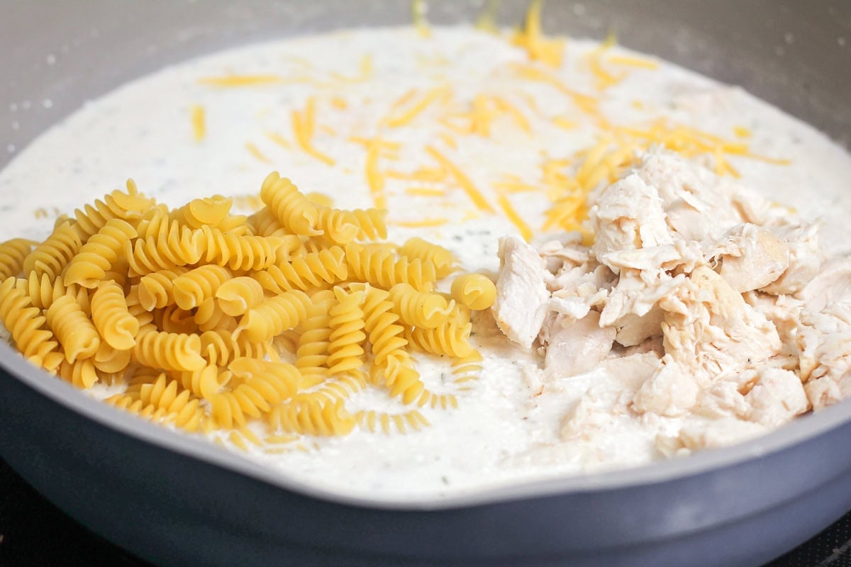 Chicken, pasta and cheese in skillet.