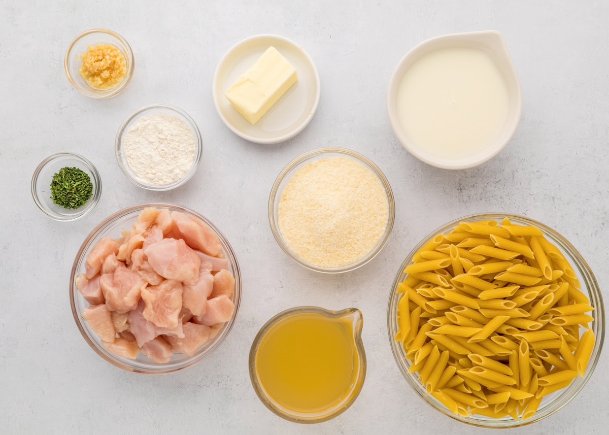 Ingredients for chicken penne pasta on a kitchen counter.