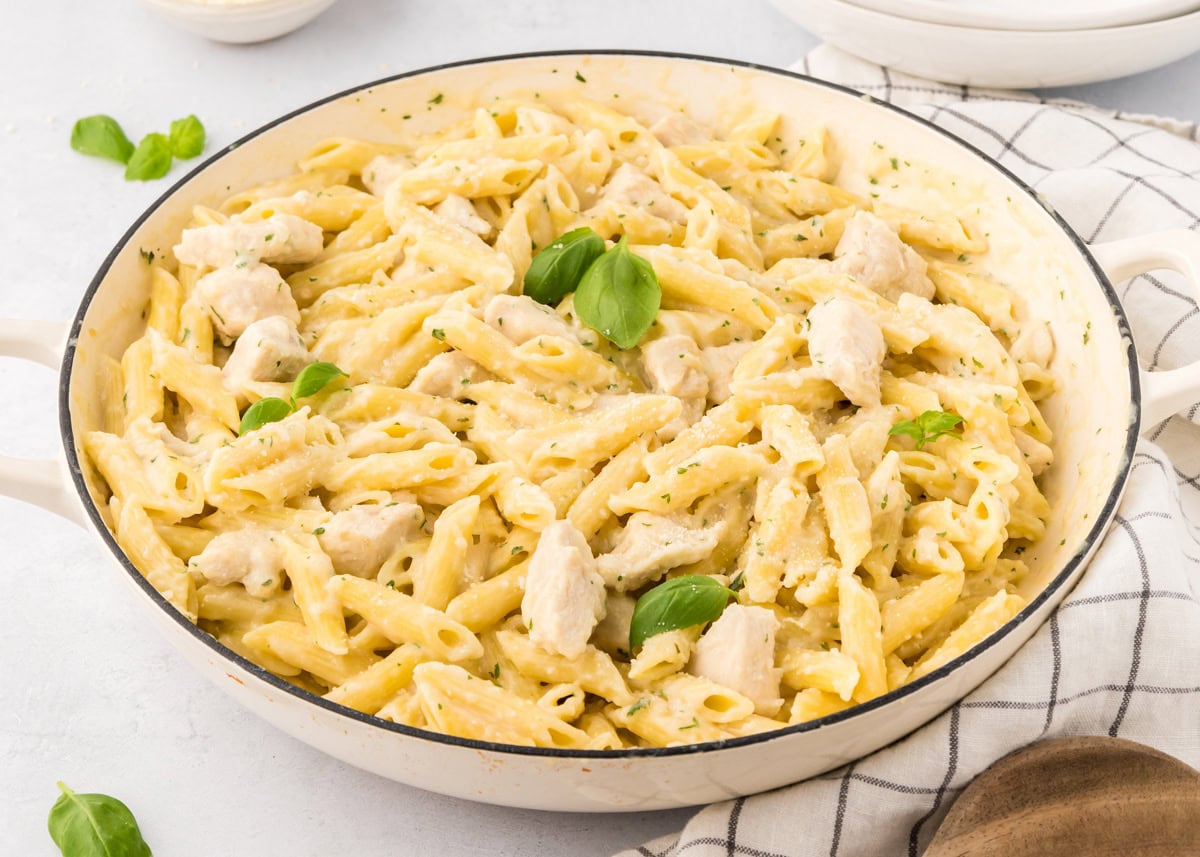 A white bowl of chicken penne pasta.