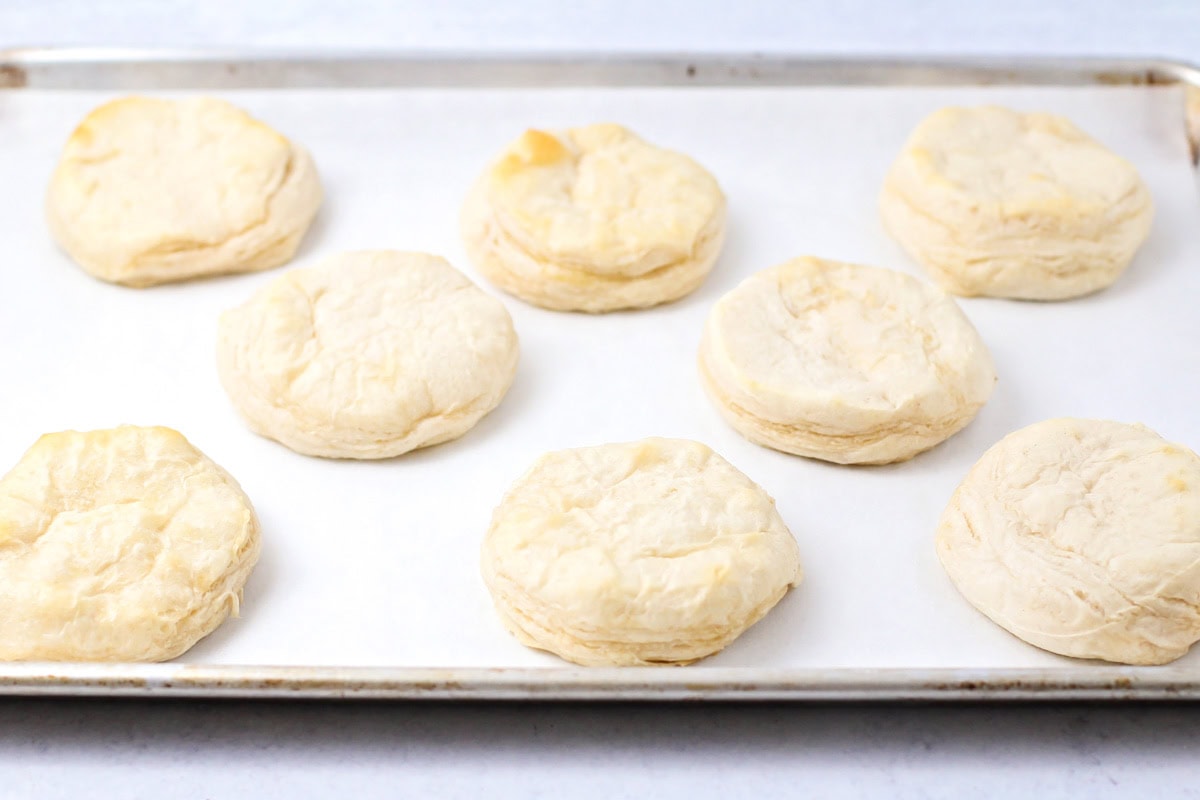 Baked biscuits on a lined baking sheet.