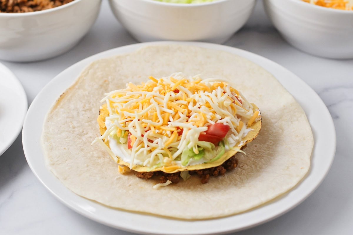 Toppings on tortilla for crunchwrap supreme.