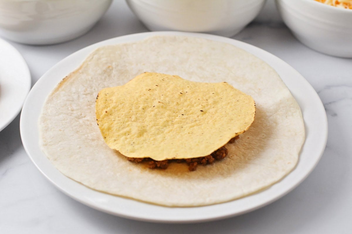 Tostada shell layered on ingredients for tortillas.
