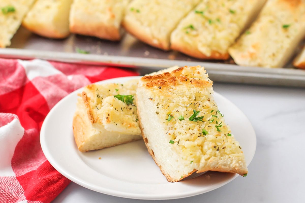 Two slice of garlic bread recipe on a white plate.