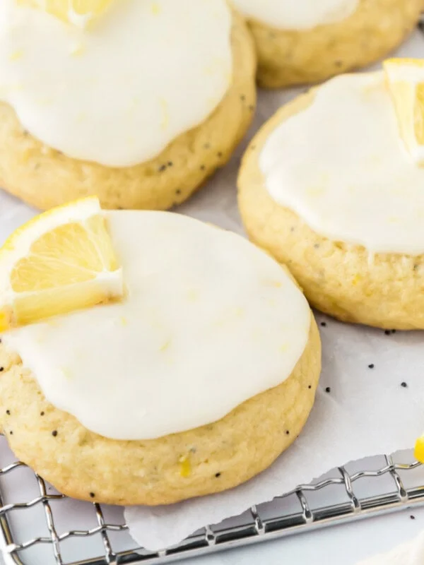 Multiple lemon poppy seed cookies on a wire cooling rack.