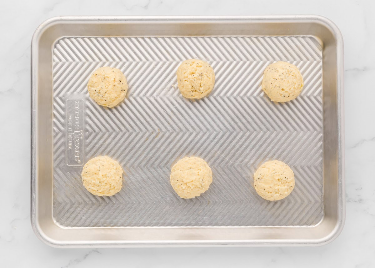 Cookie dough batter balls on a baking sheet.