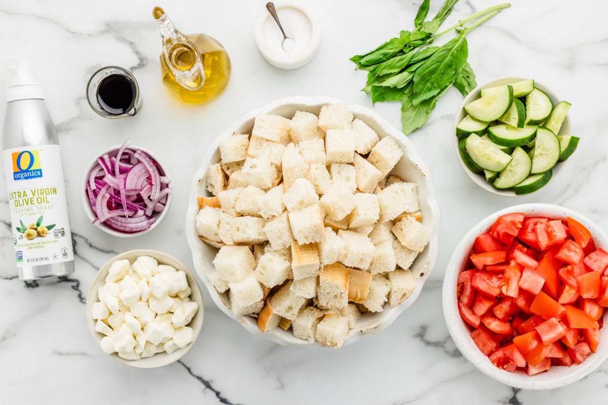 Measured ingredients for panzanella salad on a kitchen counter.