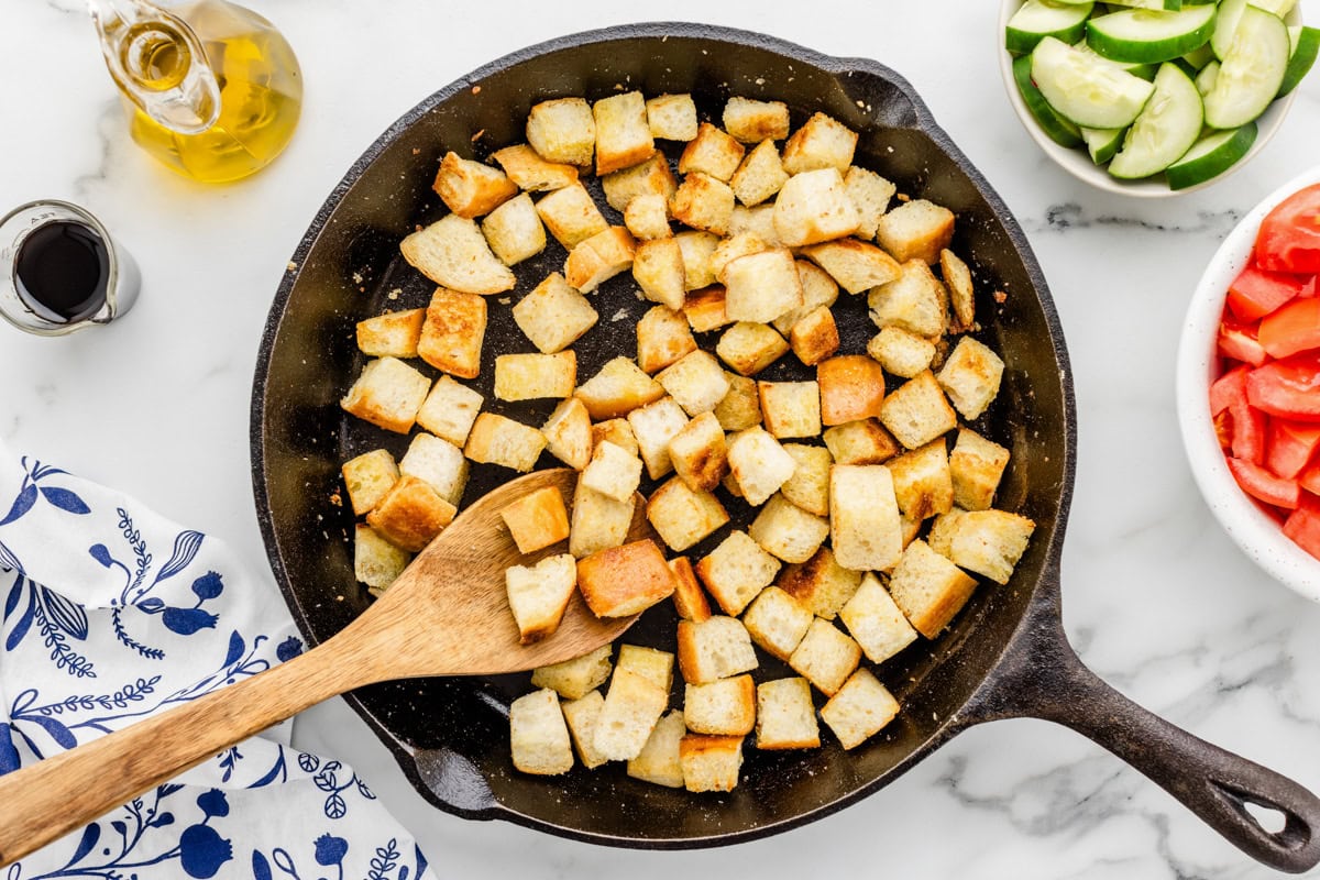 Toasting bread cubes in a skillet of oil.