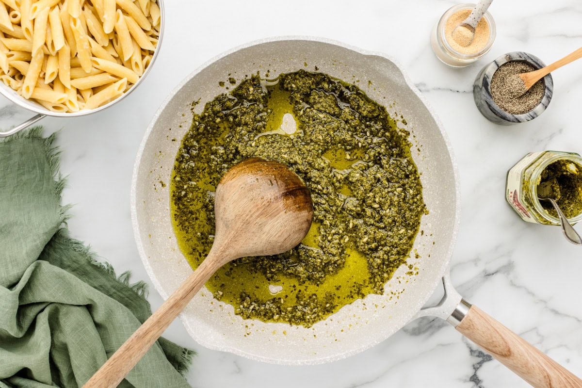 Whipping pesto ingredients in a pan.