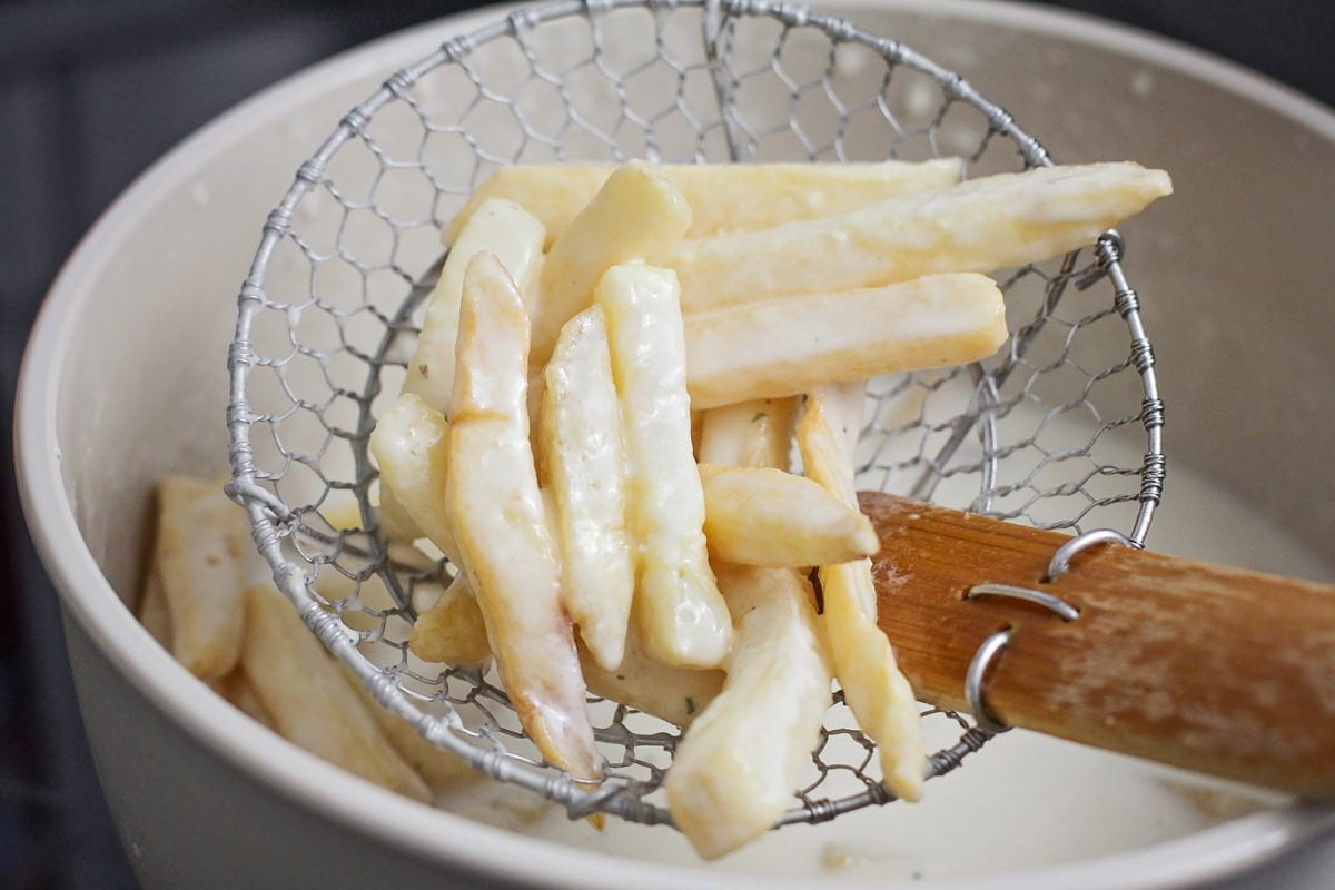 Seasoning fries in milk mixture.