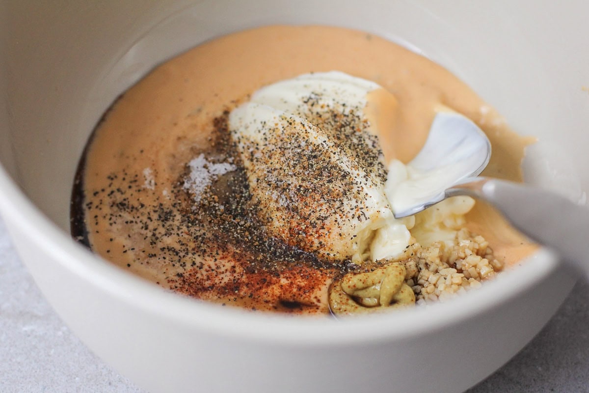 Combining ingredients to make remoulade.