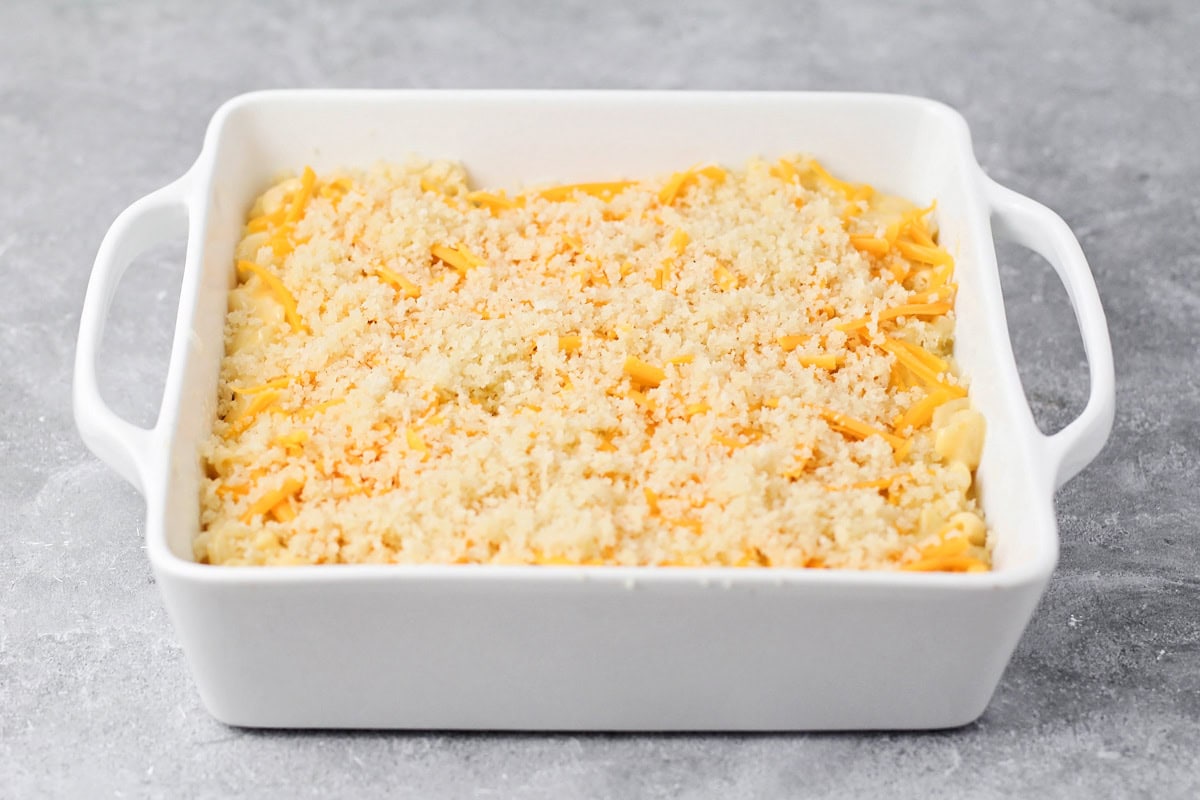 Adding panko bread crumbs and shredded cheese to the top of the velveeta mac and cheese casserole.