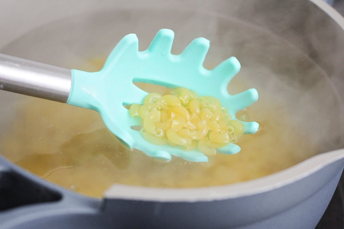 Cooking macaroni pasta in a pot of water.