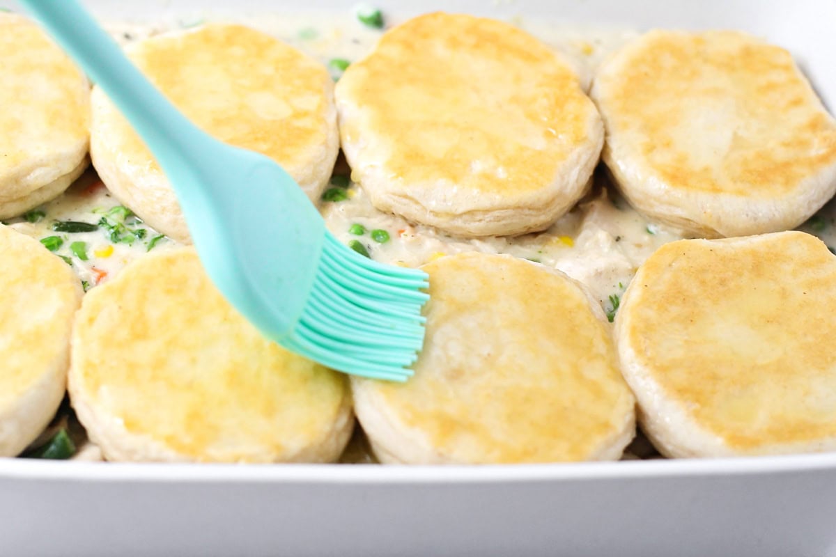 Buttering biscuits for casserole.