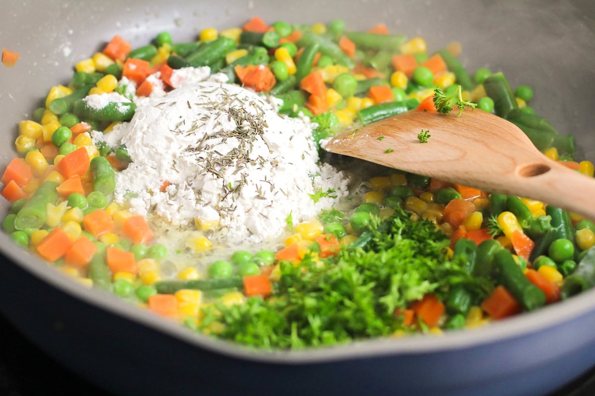 Roux being mixed into veggies in skillet.