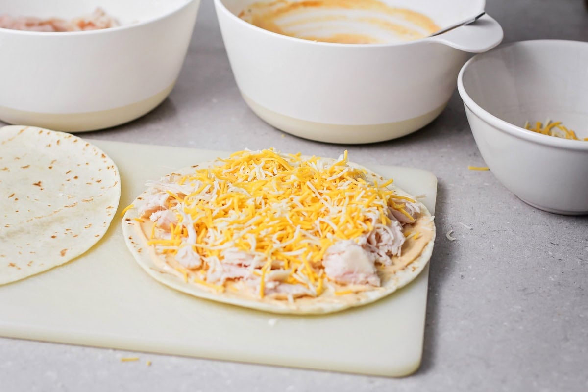Chicken and cheese on top of flour tortilla.