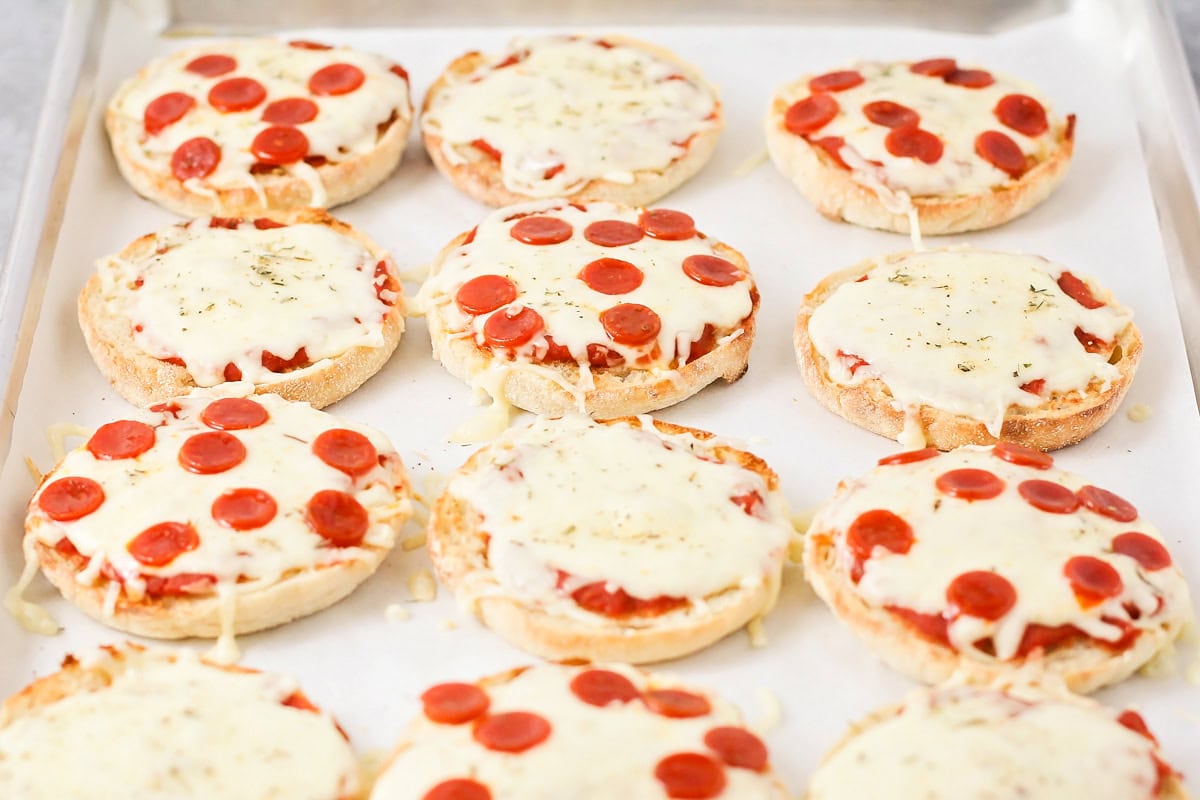 English Muffin pizzas cooked on cookie sheet with parchment paper.