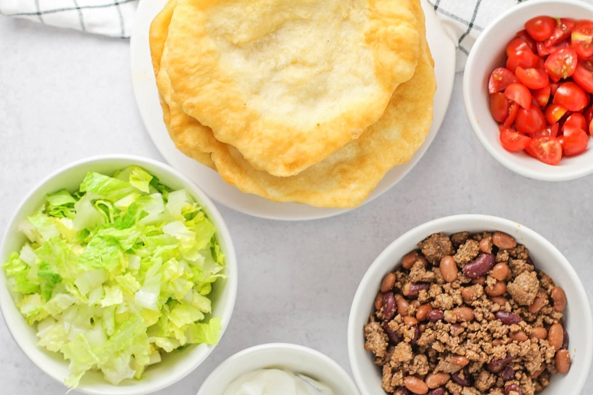 Ingredients for Fry bread on counter with bread, beans and toppings.