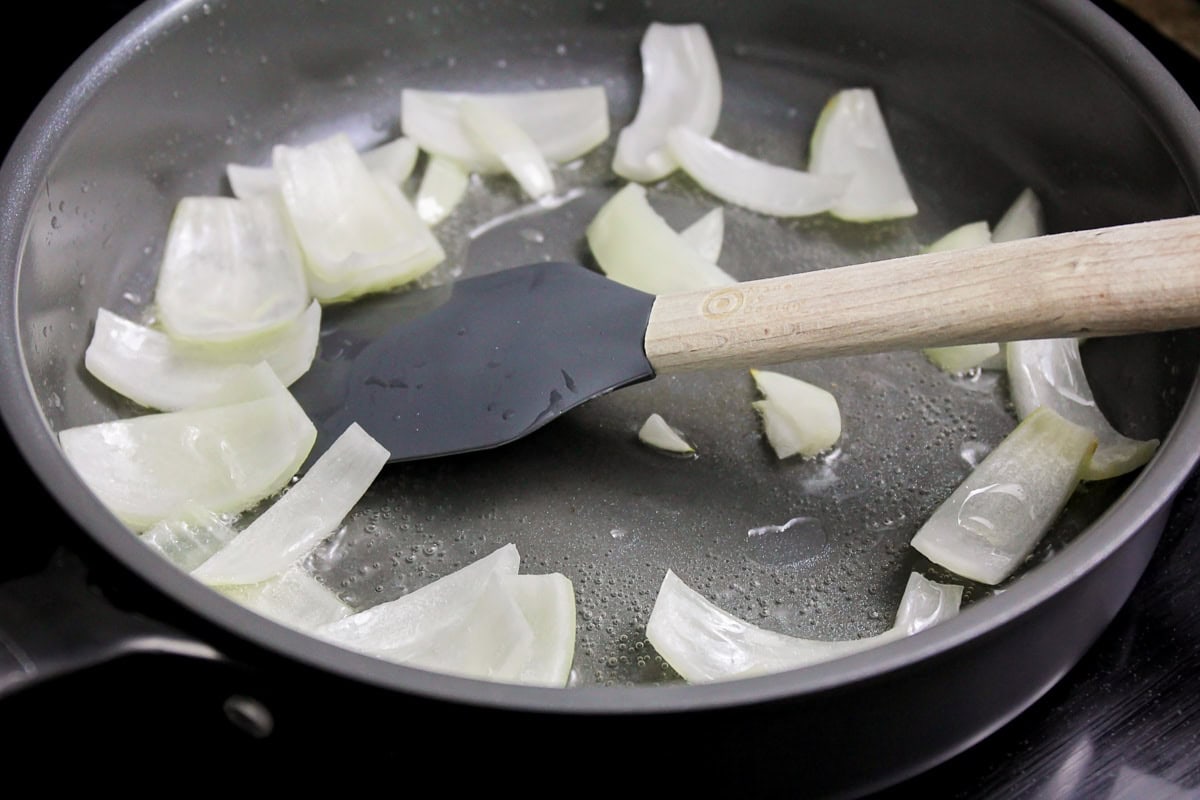 Onions being fried in skillet.