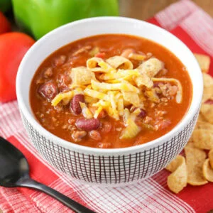 Copycat Wendy's chili recipe served in white bowl with cheese on top.