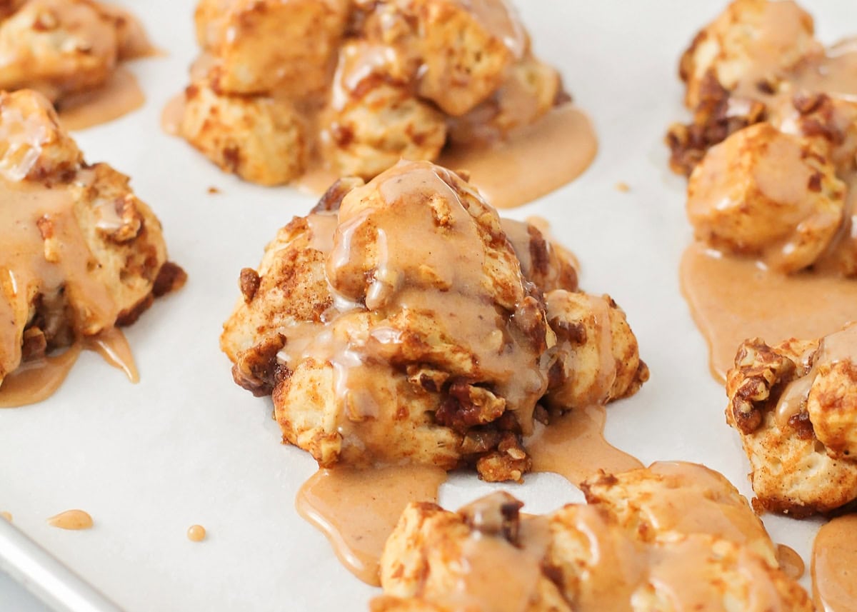 Glazed scoops of biscuit on a lined baking sheet ready for the oven.