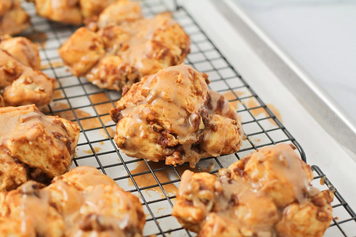 Glazed baked pumpkin fritters on a cooling rack.