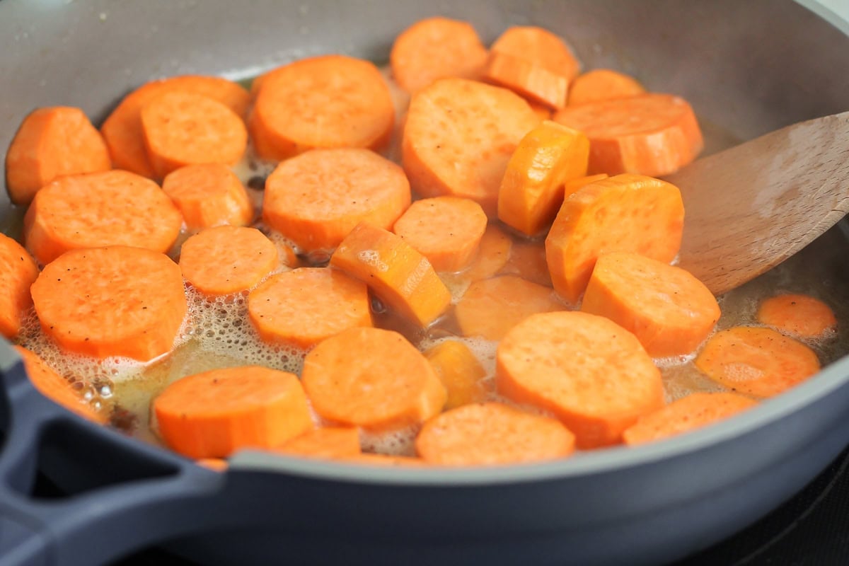 Sliced yams cooking in brown sugar and butter.