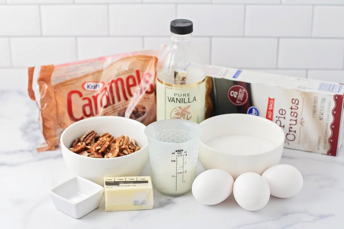 Ingredients for caramel pecan pie on a kitchen counter.