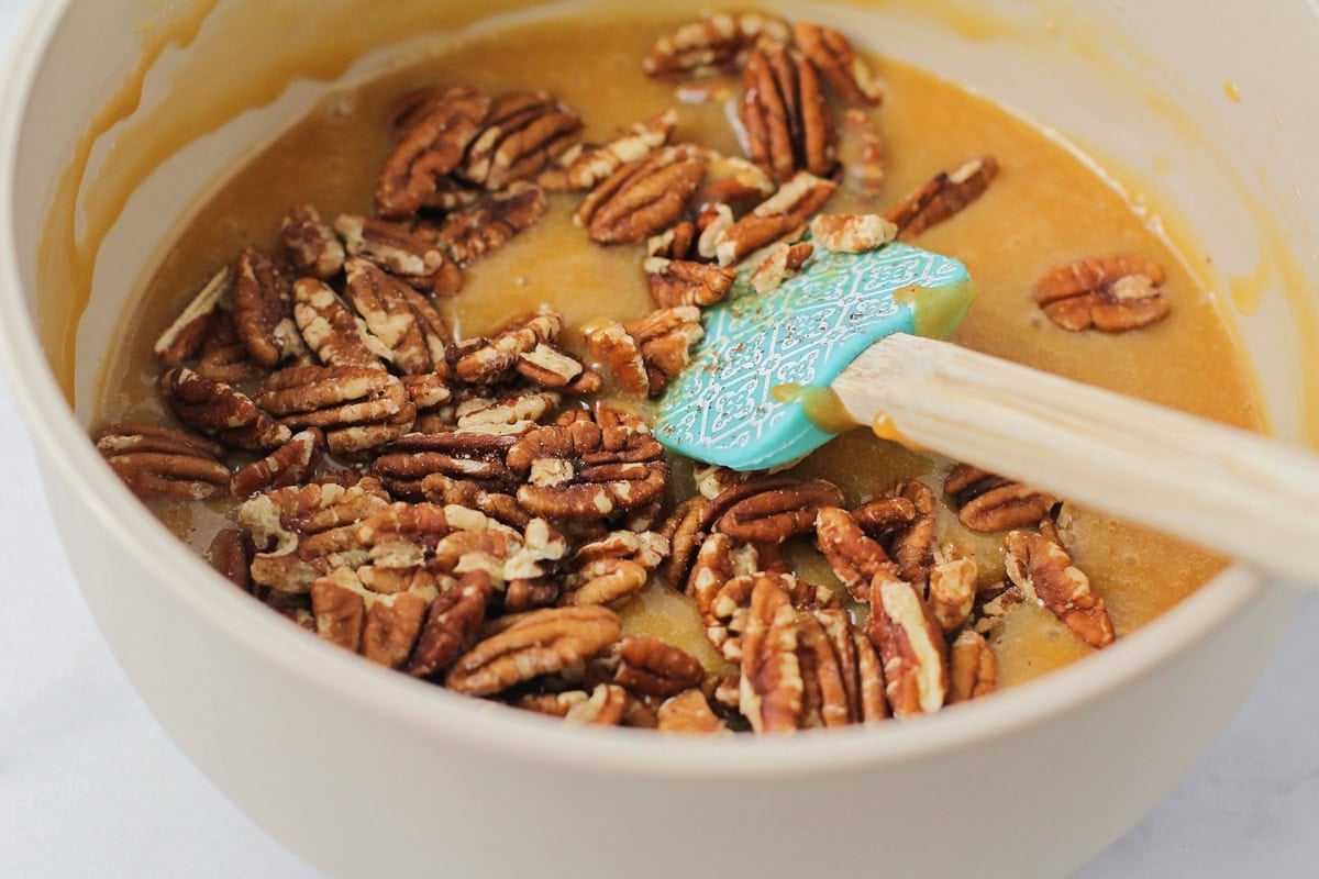 Adding pecans to the caramel filling.