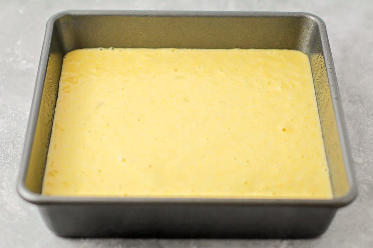 Homemade cornbread batter poured into baking dish.