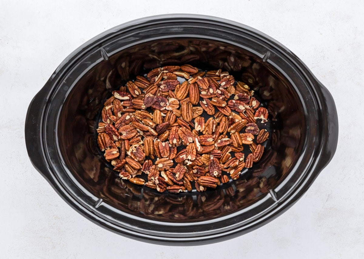 Pecans in the bottom of a slow cooker.