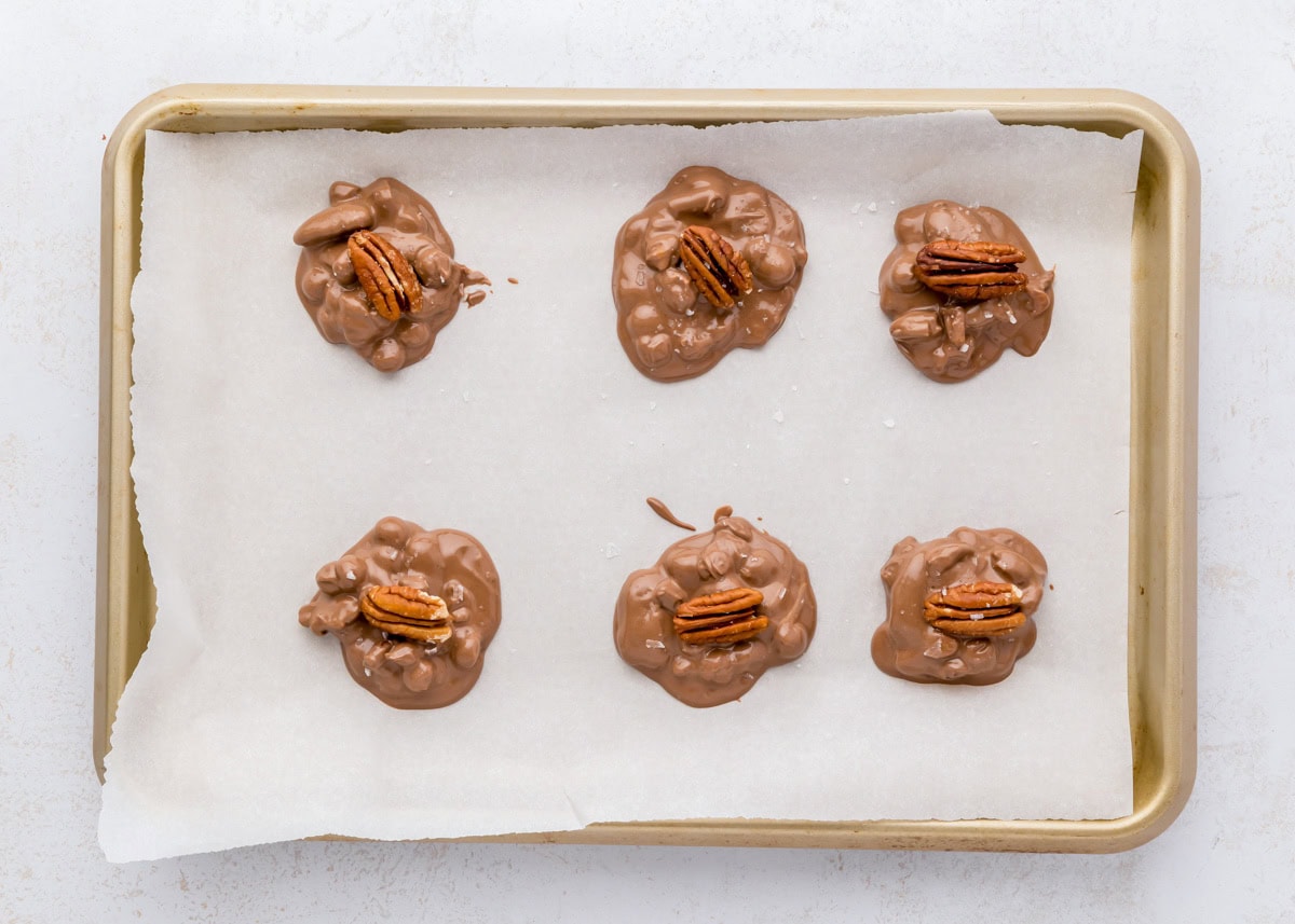 Spoonful of chocolate topped with pecan halves.