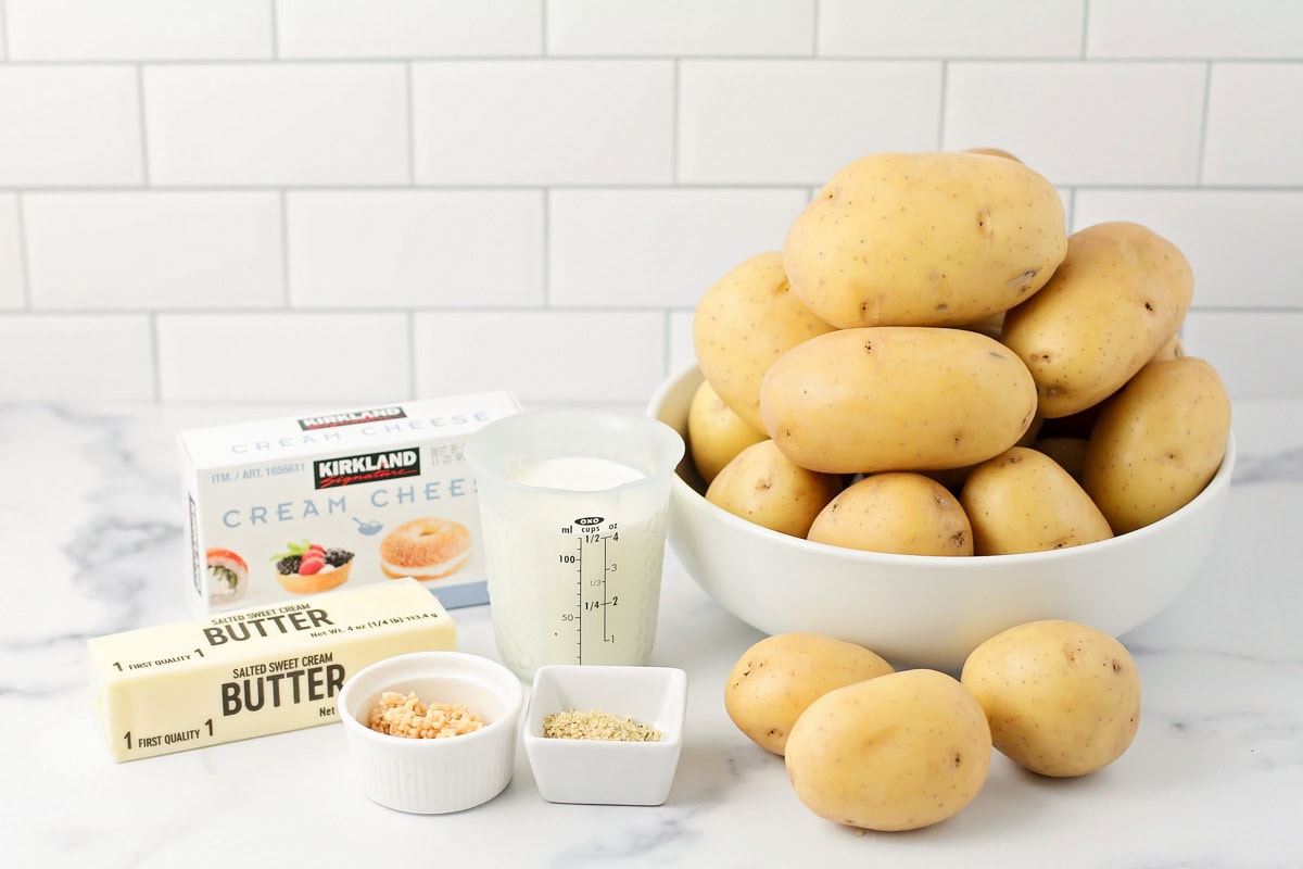 Ingredients for making garlic mashed potatoes on a kitchen counter.