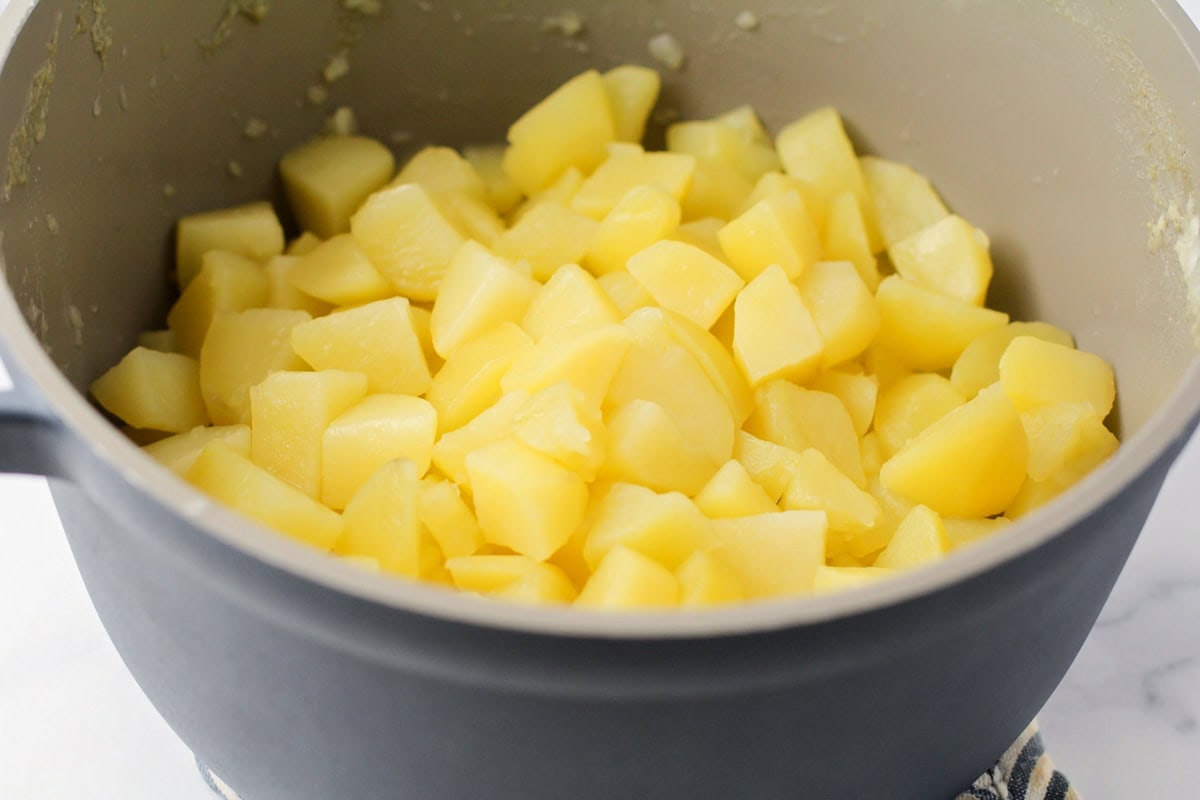 Cooked cubed potatoes in a pot.