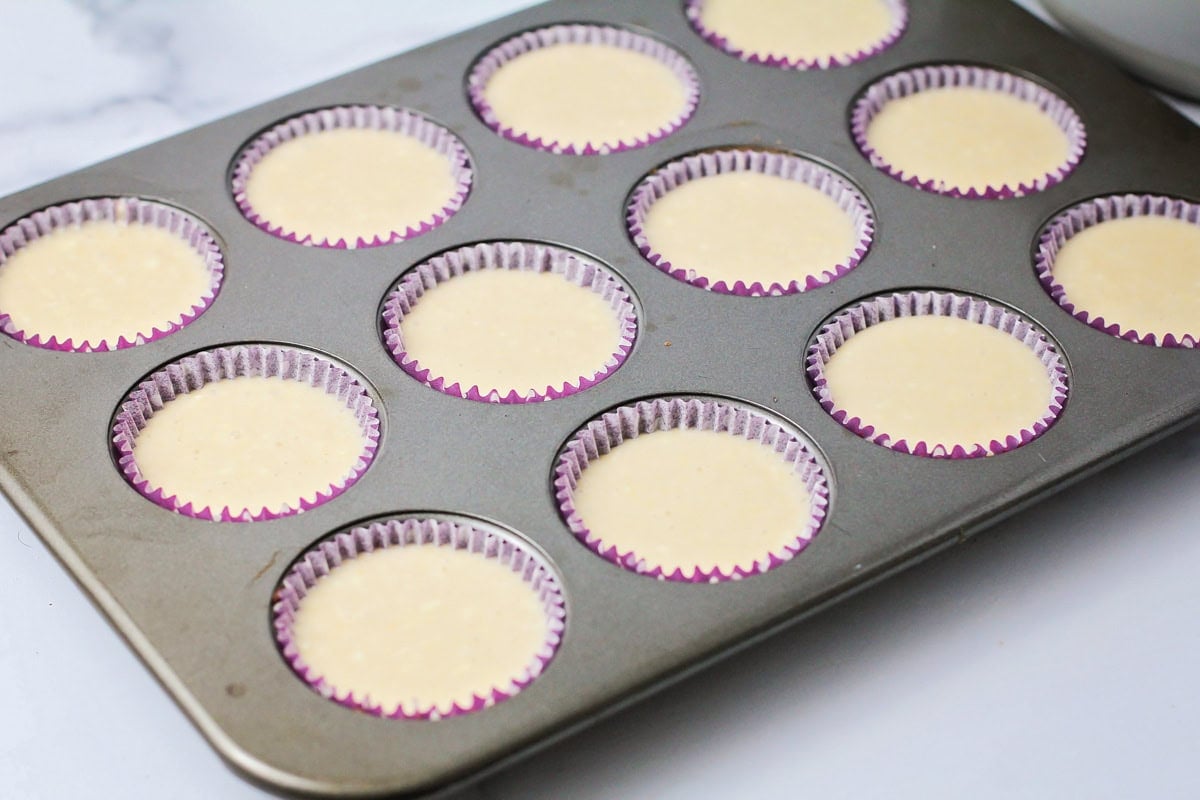 Adding cupcake batter to the tops of Oreos.