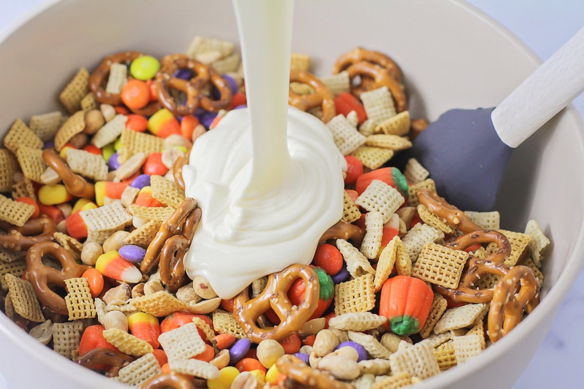 Pouring candy coating over the cereal mixture.