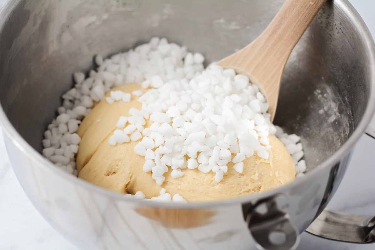 Adding sugar pearls to a yeast batter.