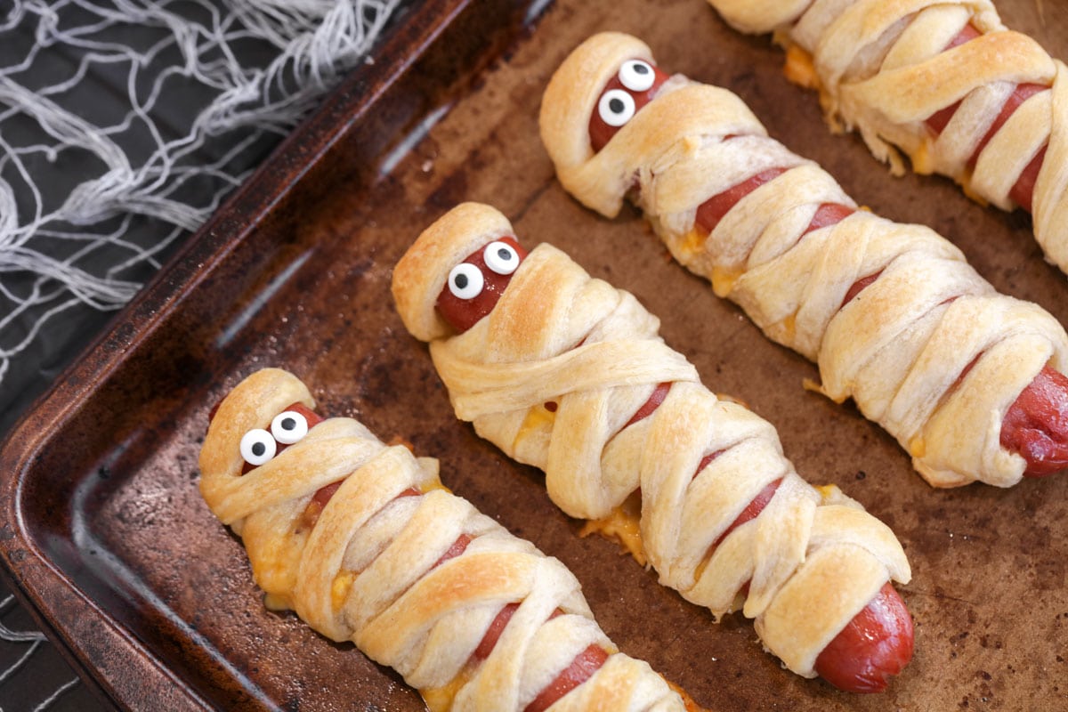 Mummy hot dogs baked on baking sheet.