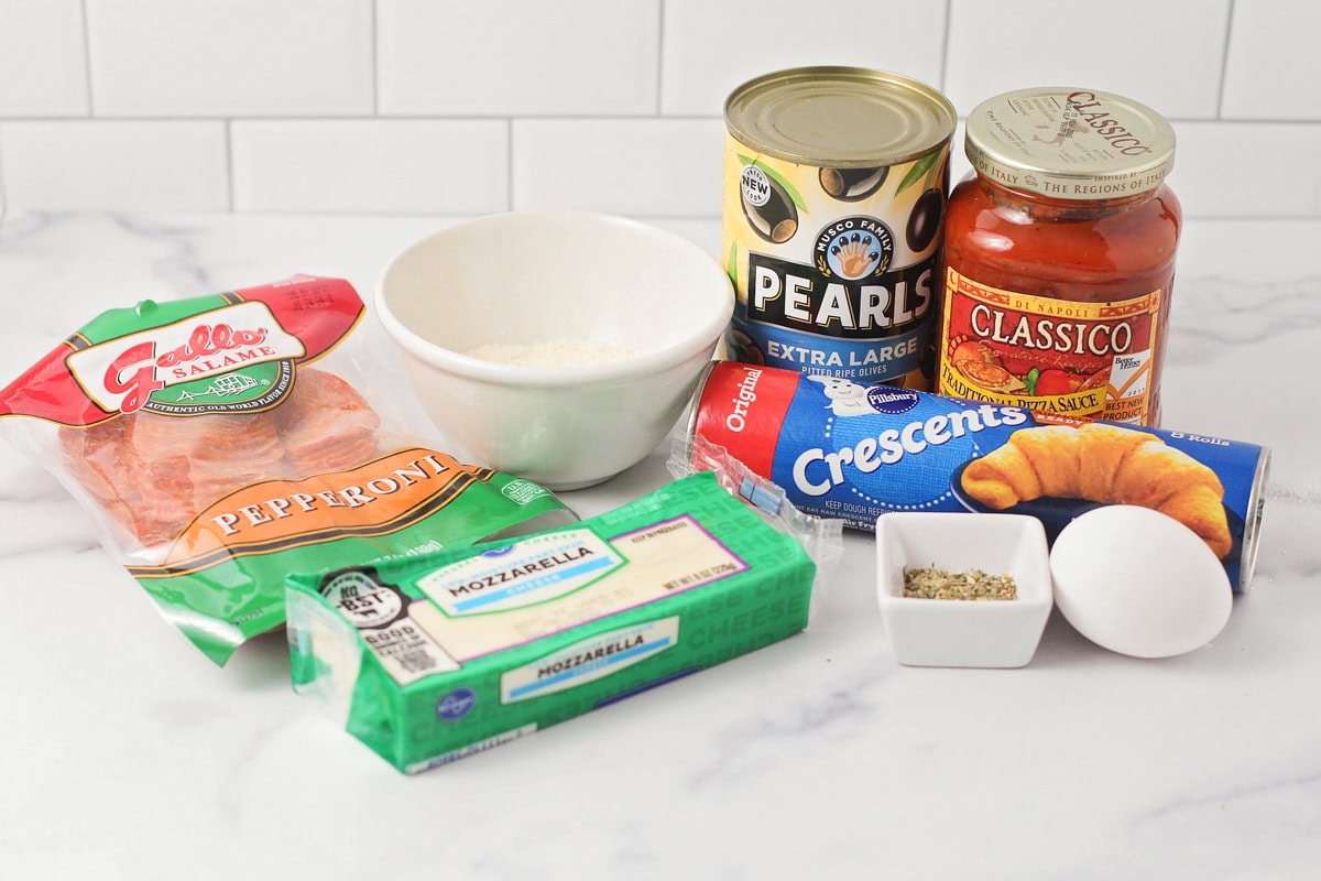 Ingredients for a crescent pizza on a kitchen counter.