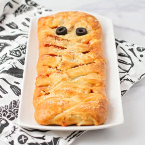 Mummy pizza recipe on white dish.