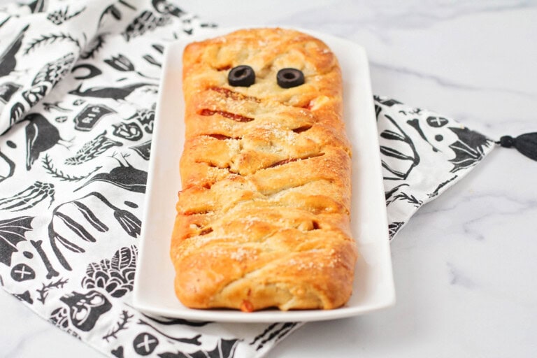 Mummy pizza recipe on white dish.