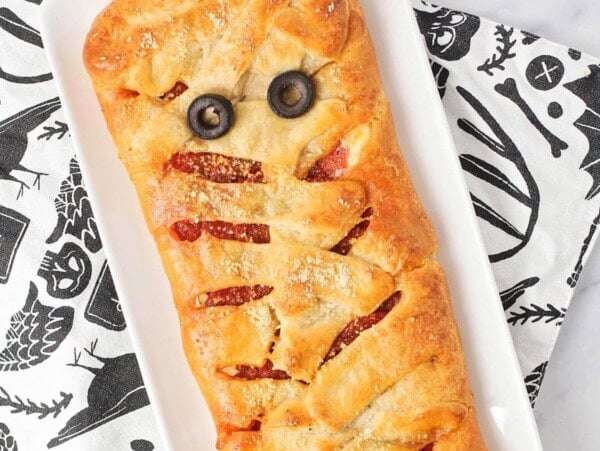 Mummy pizza made out of crescent dough and topped with olive eyes.