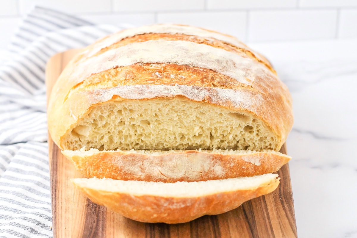 Round Loaf of No Knead Bread on a parchment lined board.