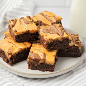 Peanut butter brownies stacked on a white plate.