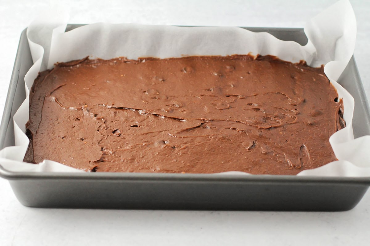 Brownie batter spread in a baking pan.