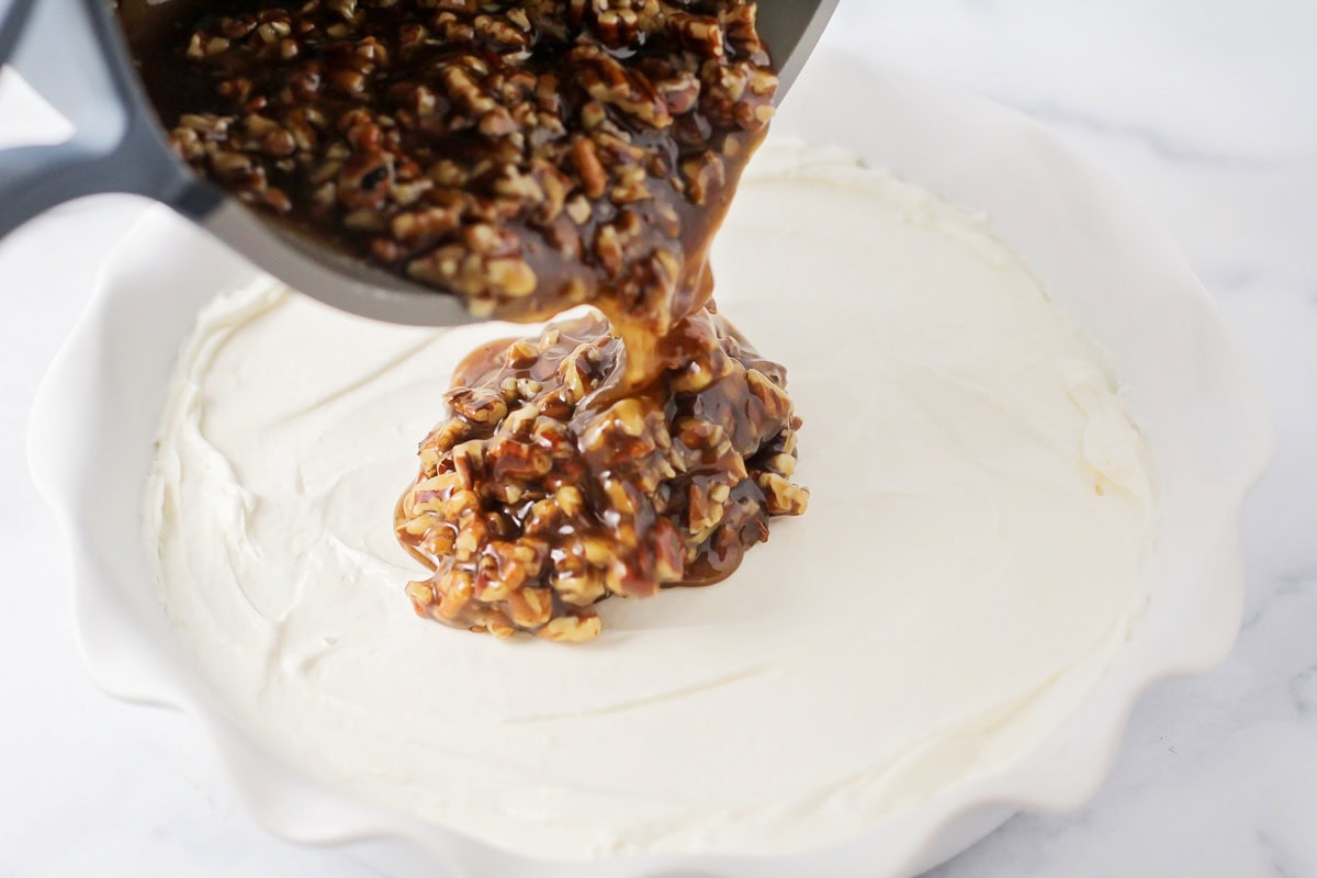 Layering pecan mixture over cream cheese layer.