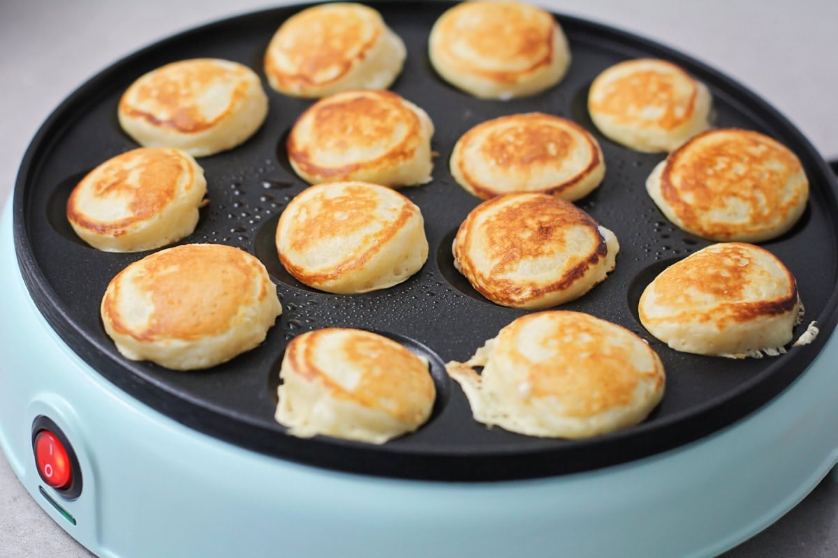 Golden brown pancakes in a poffertjes griddle.