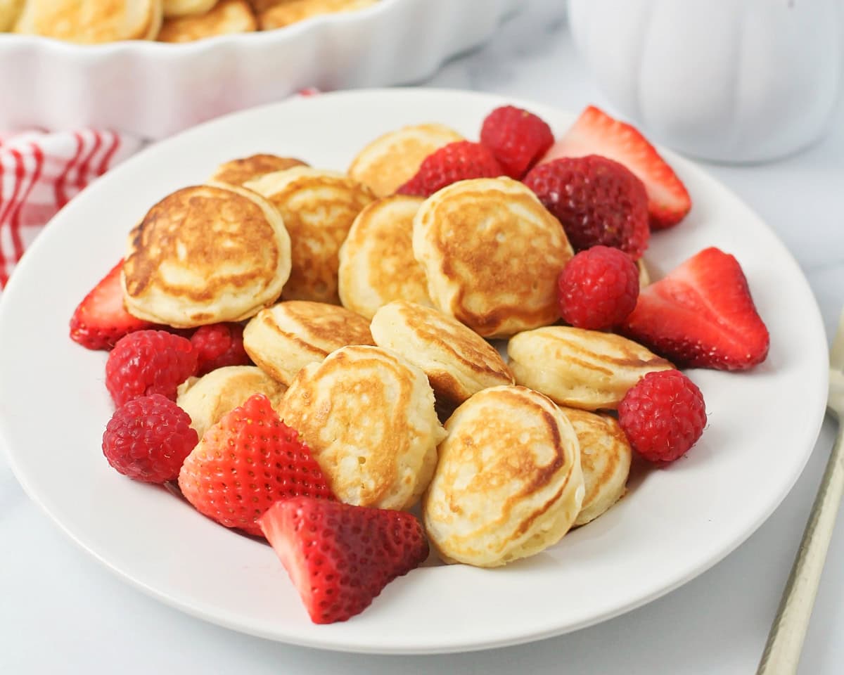 A bowl of poffertjes with fresh strawberries.