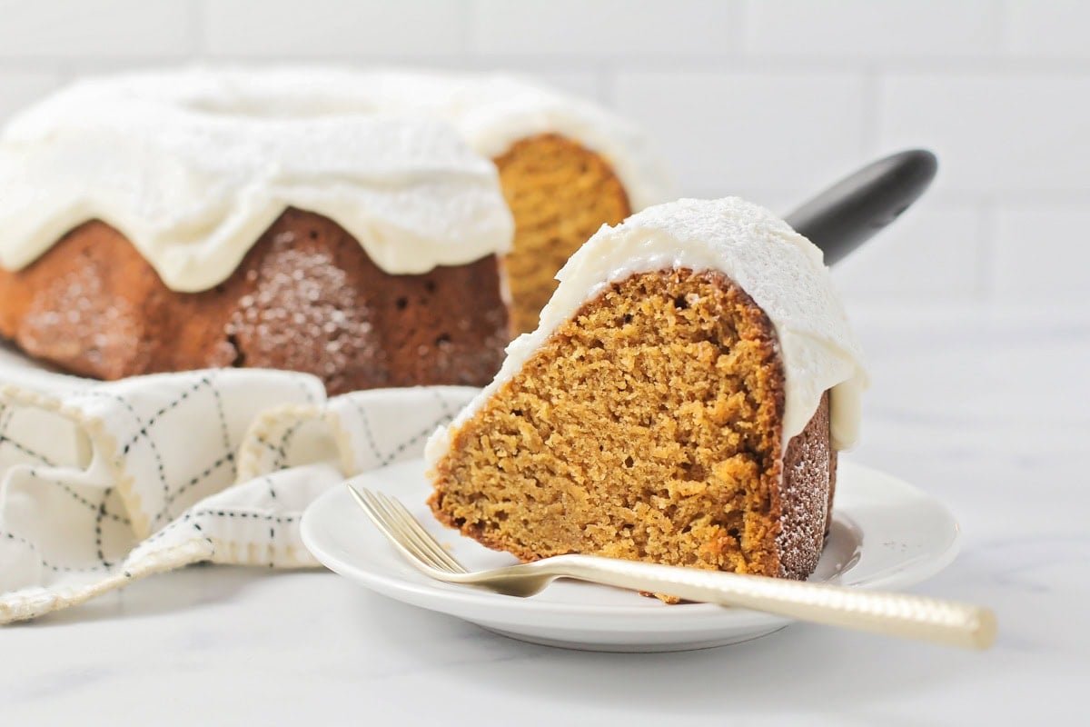 Slice of pumpkin bundt cake served on a white plate.