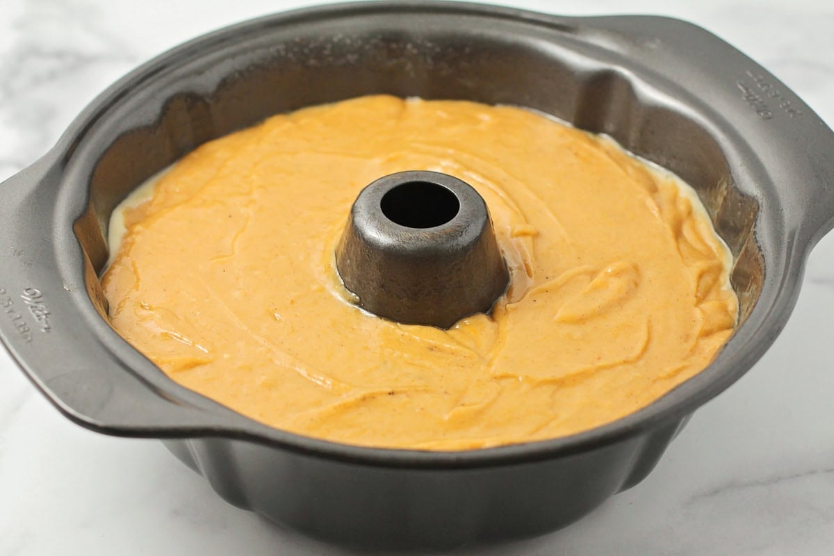 A bundt pan filled with pumpkin batter.